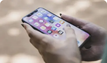 A person holding an iPhone he is development services, showcasing the latest technology in a modern setting, perfect for tech enthusiasts